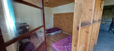 Interior of a small room featuring a mattress on the floor and partition walls