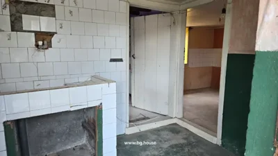 Interior room showing a tiled sink, open doorway leading to another room, and green and white painted walls.