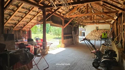 Wooden structure interior with garden tools, drying rack, and firewood.