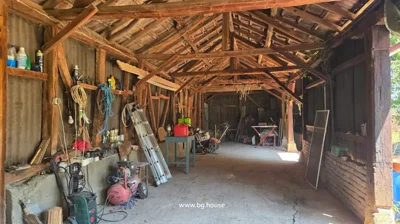 Wooden beams and shelves with tools inside structure.