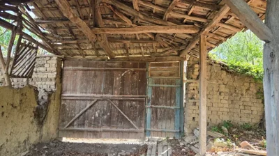 Interior of a wooden and brick structure with large wooden doors and a tiled roof