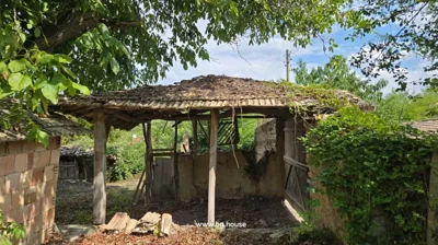 Open wooden and brick structure with tiled roof and wooden support beams