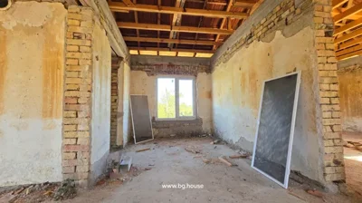 Room under construction with brick walls, window, and construction materials on the floor