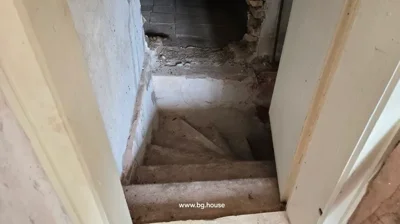 Concrete stairs leading down to a lower level, white walls surrounding the stairwell